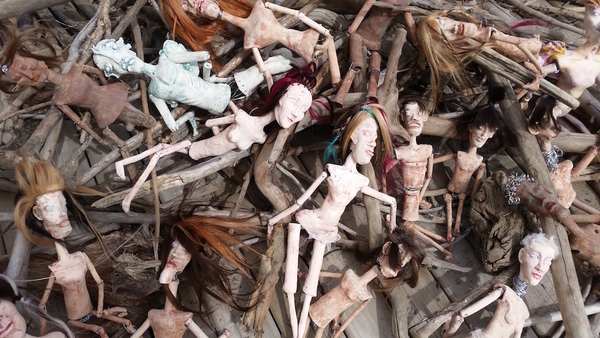 Clay dolls in drift wood